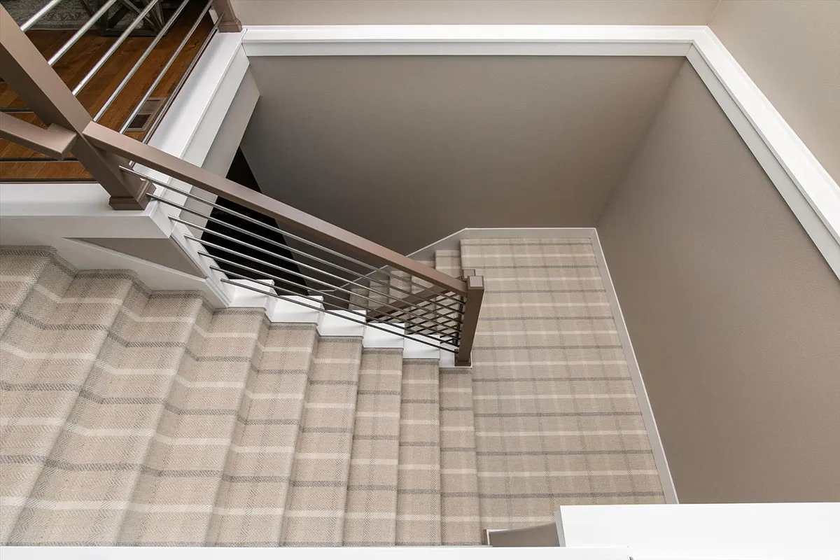 Beige walls with plaid stair carpeting 